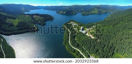 Panoramic view above Vidra Lake. The lake is located in a mountainous area, surrounded by coniferous forests. Vidra resort is built near the lake. Carpathia, Romania.  Royalty-Free Stock Photo #2032923368