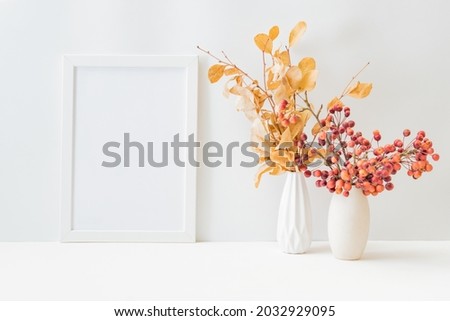 Home interior with decor elements. Mockup with a white frame, dry autumn leaves in a vase on a light background