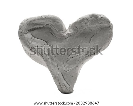 Grey modelling clay shaped in heart sculpture isolated on white background