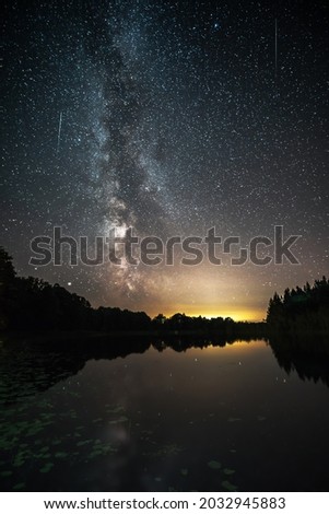 Night sky full of stars with Milky way over lake. Night starry landscape. Autumn night background.
