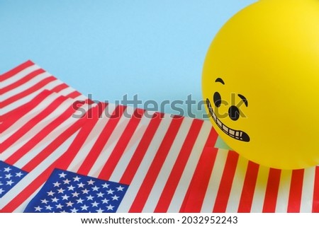 Yellow emoji balloons with American flags on a blue background.