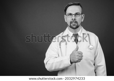 Blond bearded man doctor with goatee against gray background