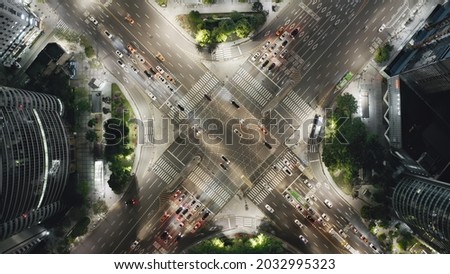 Beautiful view from above to a crossroad in Seoul Gangnam District on the night. Cars, buses and other vehicles crossing busy intersection surrounded by modern skyscrapers. Royalty-Free Stock Photo #2032995323