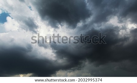 Picturesque time of black stormy clouds moving heavily on the dark sky creating dangerous and dramatic atmosphere.