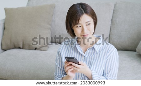 Young woman looking at a smartphone in the living room