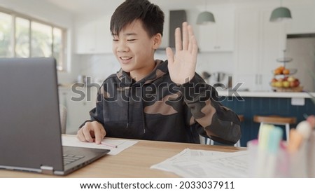 Mixed Asian preteen teen boy making video calling with laptop at home, using  online virtual class , social distancing, homeschooling, remote learning, new normal concept