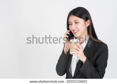 Beautiful Asian business woman using mobile telephone and holding hot coffee cup isolated on white background with copy space - lifestyle business people concept