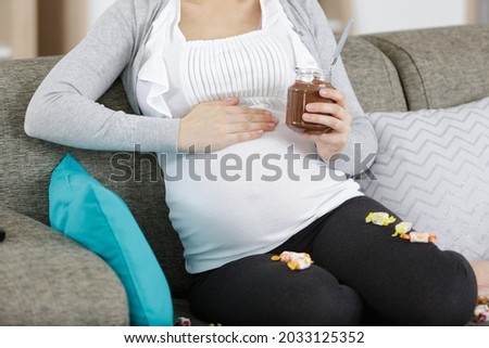 a pregnant woman eating spreadable chocolate