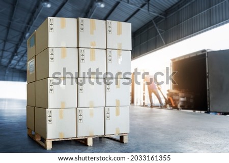 Stack of Package Boxes on Pallet Load with Shipping Cargo Container. Truck Parked Loading at Dock Warehouse. Delivery. Supply Chain Shipment Boxes. Warehouse Logistics. Cargo Freight Truck Transport. Royalty-Free Stock Photo #2033161355