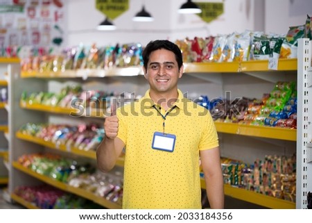 Happy young man show thumbs up at grocery store products. Royalty-Free Stock Photo #2033184356