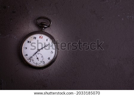 Old pocket watch on dark background with copy space