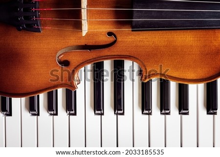 Violin on top of piano keyboard background with copy space for music concept