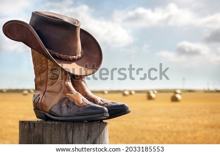 Cowboy boots and hat at ranch, country music festival live concert or line dancing concept Royalty-Free Stock Photo #2033185553