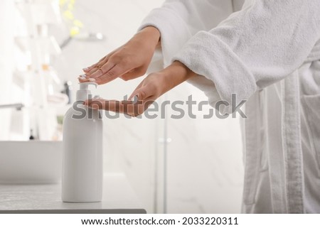 Teenage girl using gel in bathroom, closeup. Skin care cosmetic
