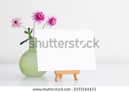 Blank white card mockup and rose flowers in glass vase. 