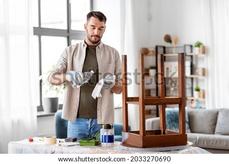 furniture restoration, diy and home improvement concept - man applying solvent to rag and renovating old wooden table Royalty-Free Stock Photo #2033270690