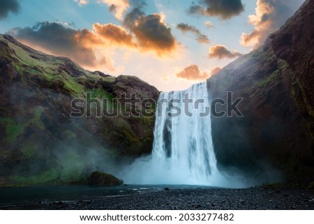 Famous Skogafoss waterfall on Skoga river in sunset time. Iceland, Europe. Great purple sky glowing on background. Landscape photography
