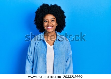 Young african american woman wearing casual clothes with a happy and cool smile on face. lucky person. 