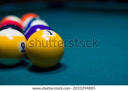 pool or billiards balls on  blue table . focus on the ball number 1