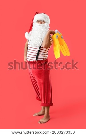 Santa Claus with paddles on color background. Christmas vacation
