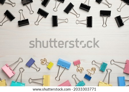 Binder clips on white wooden background, flat lay. Space for text