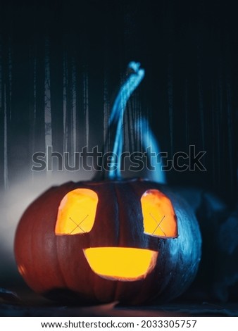 Glowing Pumpkin lantern close-up, gloomy forest background