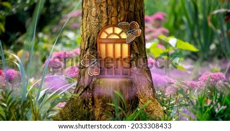 Fantasy fairy tale forest with magical shining window of enchanted elf or gnome house in hollow of pine tree, blooming fabulous pink flowers garden, flying Common blue butterflies on magic sunny glade