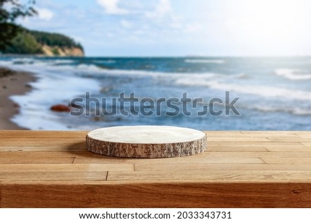 Wooden platform on the table for standing product against the background of the autumn sea landscape with the midday sun 