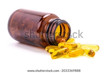 Fish Oil supplement capsules for health spill out from brown glass bottle isolated on white background Royalty-Free Stock Photo #2033369888