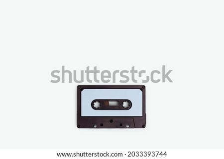 Cassette tape on a blue pastel background. Minimalistic composition with copyspace.