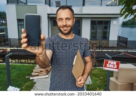 Confident real estate agent advertising his company