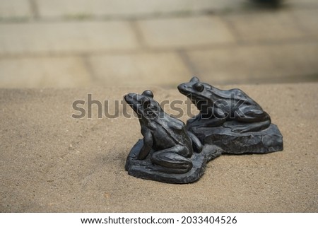 Two iron frogs in park