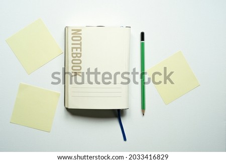 notebook with space for text, office, yellow cards, reminders, stickers, blue tab, green pencil, on a white background, photo from above