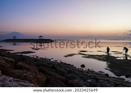 Silhouette of photographer taking picture of landscape during sunrise