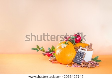 Autumn composition, Thanksgiving holiday greeting card. Pumpkin cooking background, with fall festive decor, small pumpkins, spices, pecan nuts, trendy colorful orange background copy space 