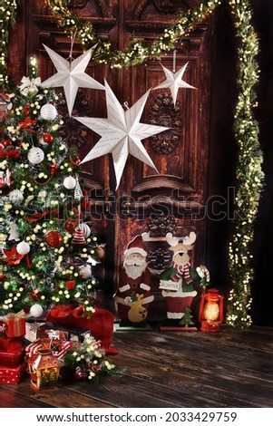 Christmas background with Christmas tree with white and red ornaments and standing wooden decorations in rustic style interior 