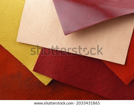 Different colors natural leather textures samples on red leather background