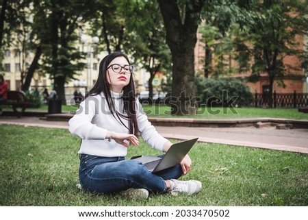 Pretty student using laptop on campus city