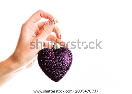 Holding Christmas ornaments against white background