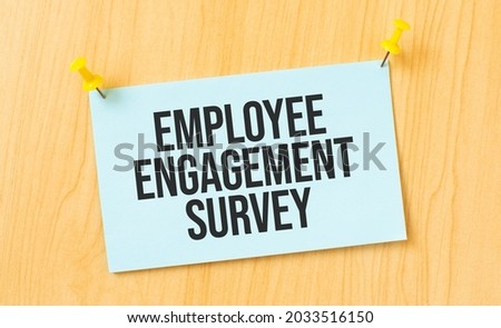 Employee Engagement Survey sign written on sticky note pinned on wooden wall