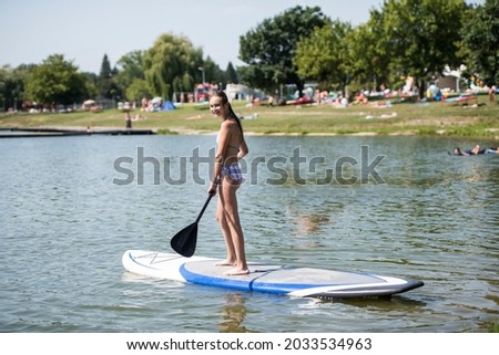 young girl on paddle board in the sea 