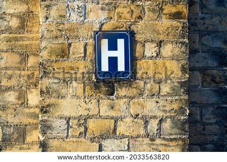 The letter H on a sign on a wall Royalty-Free Stock Photo #2033563820