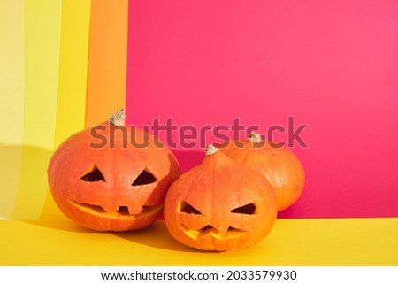 Halloween Pumpkins three jack lantern from pumpkin on colored geometric background, copy space, halloween decoration concept