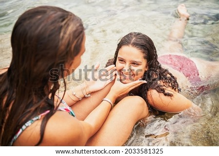 Two young cheerful women having fun on the beach
