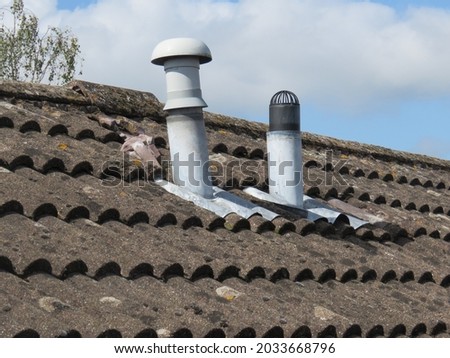 Soil vent pipes on a tiled roof Royalty-Free Stock Photo #2033668796