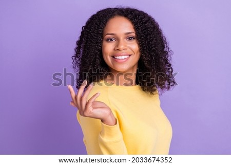 Photo of cute adorable dark skin woman wear yellow sweater smiling rising arm hands isolated violet color background