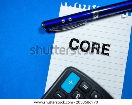 Business concept.Text CORE writing on notepaper with pen and calculator on blue background. Royalty-Free Stock Photo #2033686970