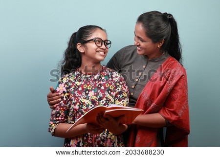 Indian ethnic mother helps daughter in her studies Royalty-Free Stock Photo #2033688230