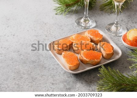 Appetizer canape of ciabatta with red caviar on gray stone table. Christmas, New Year holidays party. Festive food. Close up.