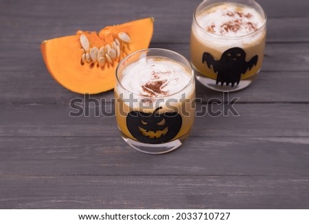 Top view of glass glasses with Halloween-themed drawings with pumpkin latte . Drinks for Halloween
